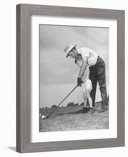 Father Teaching His Small Son How to Play Golf-null-Framed Photographic Print