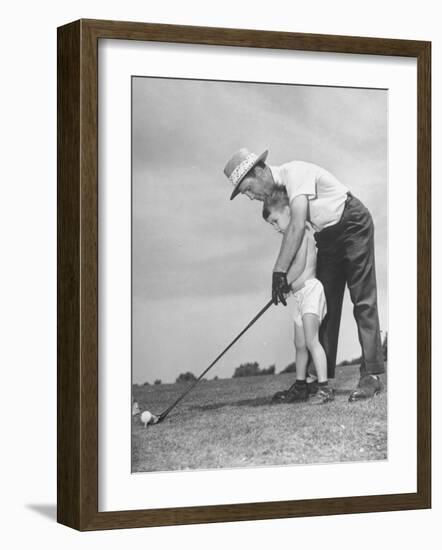 Father Teaching His Small Son How to Play Golf-null-Framed Photographic Print