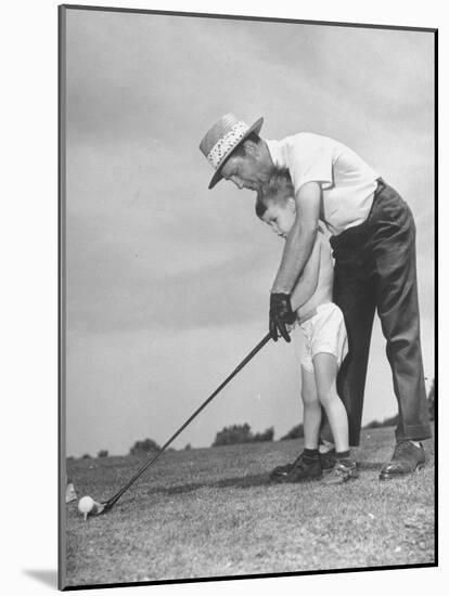 Father Teaching His Small Son How to Play Golf-null-Mounted Photographic Print