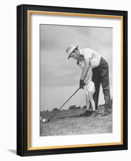 Father Teaching His Small Son How to Play Golf-null-Framed Photographic Print