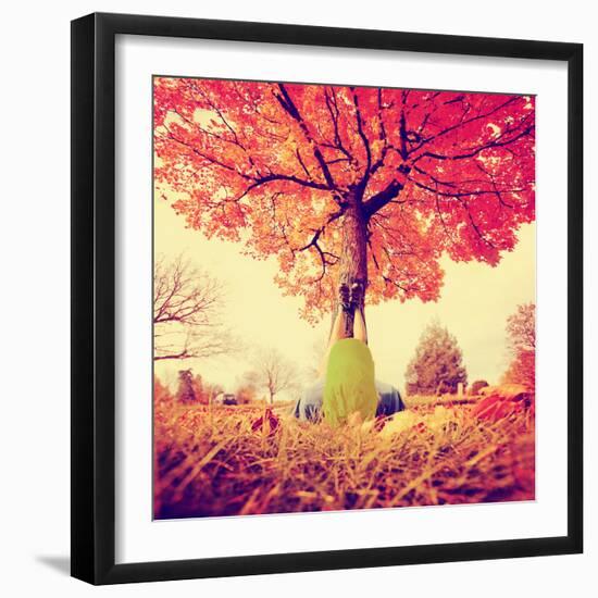 Feet Resting on a Tree Trunk during Fall When the Leaves are Turning Colors Toned with a Retro Vint-graphicphoto-Framed Photographic Print