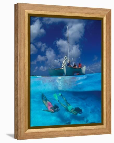 Female Divers Submerged Below Catamaran-Amos Nachoum-Framed Premier Image Canvas