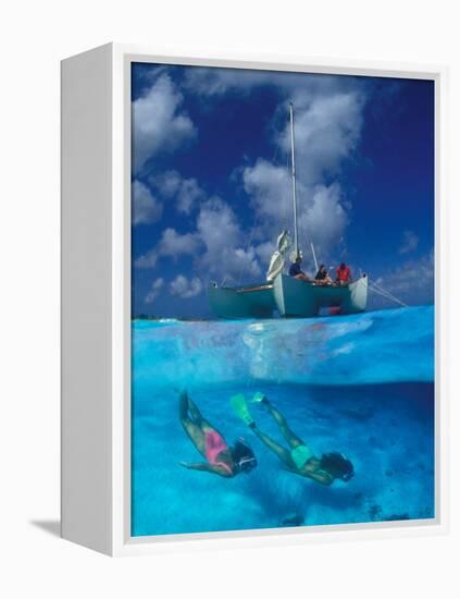 Female Divers Submerged Below Catamaran-Amos Nachoum-Framed Premier Image Canvas