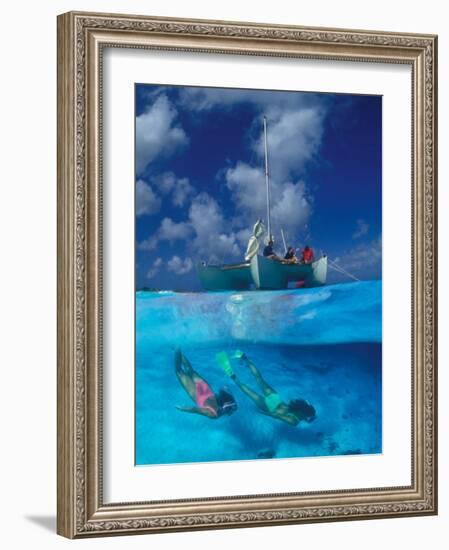 Female Divers Submerged Below Catamaran-Amos Nachoum-Framed Photographic Print