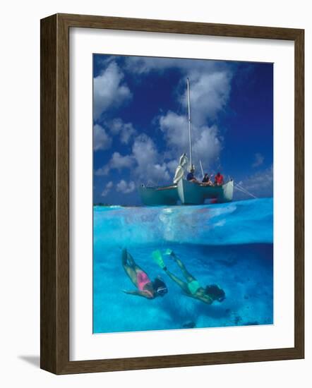 Female Divers Submerged Below Catamaran-Amos Nachoum-Framed Photographic Print