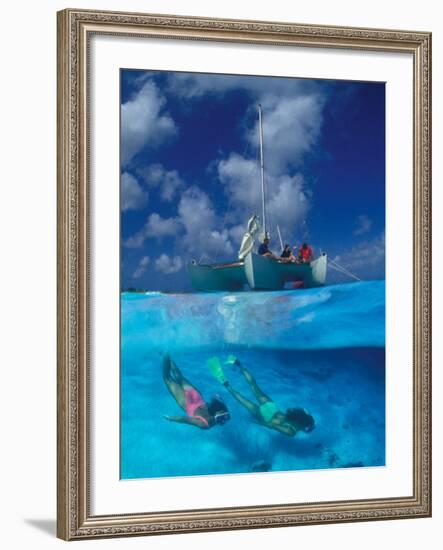 Female Divers Submerged Below Catamaran-Amos Nachoum-Framed Photographic Print