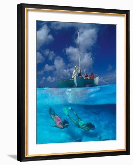 Female Divers Submerged Below Catamaran-Amos Nachoum-Framed Photographic Print