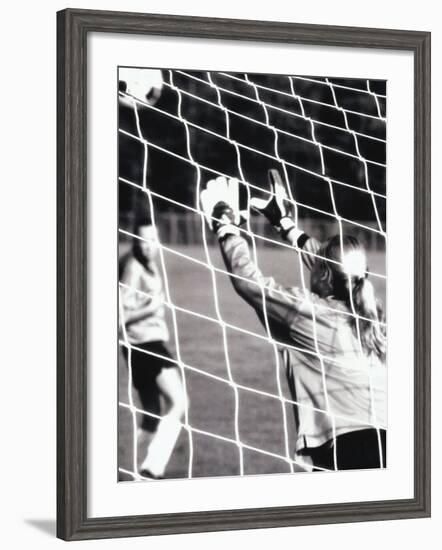 Female Goalie Attempting to Stop a Soccer Ball-null-Framed Photographic Print