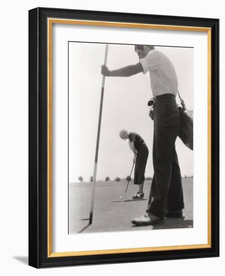 Female Golfer and Her Caddy-null-Framed Photo