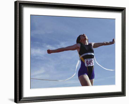 Female Runner Victorious at the Finish Line in a Track Race-null-Framed Photographic Print