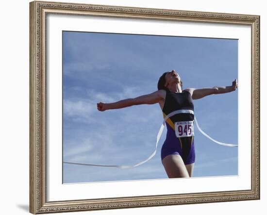 Female Runner Victorious at the Finish Line in a Track Race-null-Framed Photographic Print