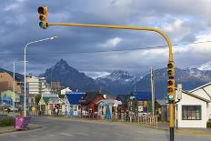 Colourful houses on touristic road framed by traffic lights post with snowy mountain chain beyond, -Fernando Carniel Machado-Photographic Print
