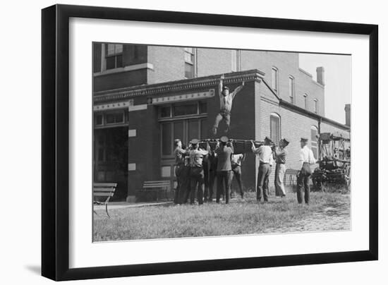 Firefighter Jumps Into Net Held By Fellow Firemen-null-Framed Art Print