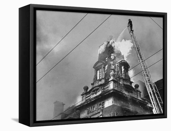 Fireman on Ladder Using a Hose to Extinguish Blazing Building Set Afire-Hans Wild-Framed Premier Image Canvas