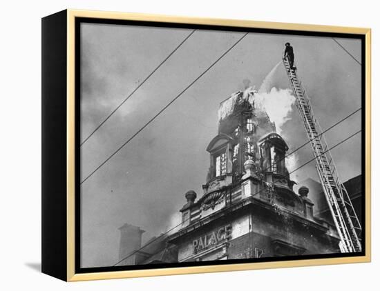 Fireman on Ladder Using a Hose to Extinguish Blazing Building Set Afire-Hans Wild-Framed Premier Image Canvas