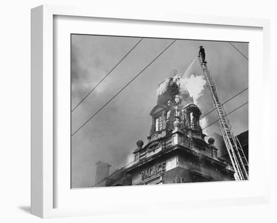 Fireman on Ladder Using a Hose to Extinguish Blazing Building Set Afire-Hans Wild-Framed Photographic Print