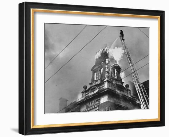 Fireman on Ladder Using a Hose to Extinguish Blazing Building Set Afire-Hans Wild-Framed Photographic Print