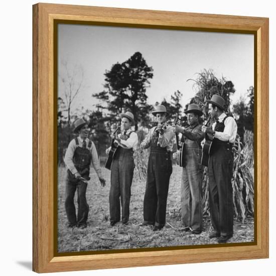 Five Male Musicians Dressed in Hats and Bib Overalls Standing in a Field-Eric Schaal-Framed Premier Image Canvas