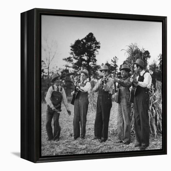 Five Male Musicians Dressed in Hats and Bib Overalls Standing in a Field-Eric Schaal-Framed Premier Image Canvas