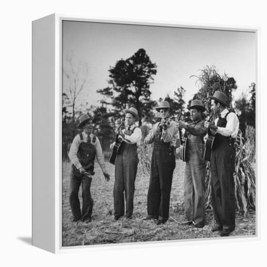 Five Male Musicians Dressed in Hats and Bib Overalls Standing in a Field-Eric Schaal-Framed Premier Image Canvas