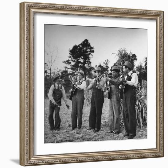 Five Male Musicians Dressed in Hats and Bib Overalls Standing in a Field-Eric Schaal-Framed Photographic Print