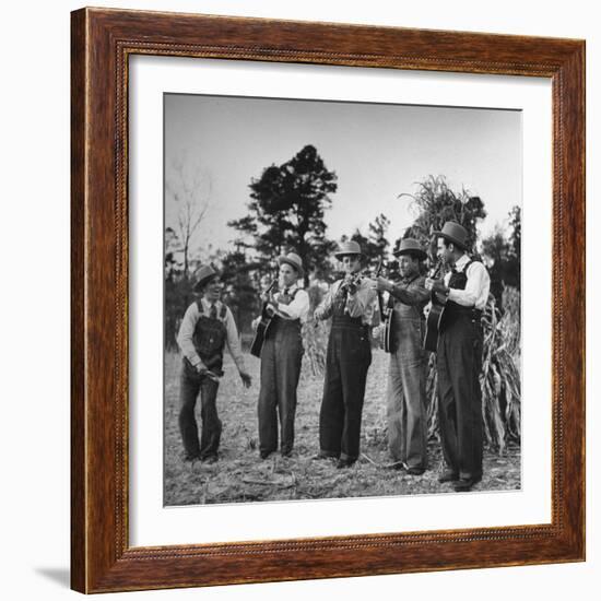 Five Male Musicians Dressed in Hats and Bib Overalls Standing in a Field-Eric Schaal-Framed Photographic Print