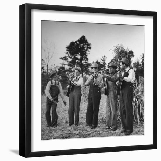 Five Male Musicians Dressed in Hats and Bib Overalls Standing in a Field-Eric Schaal-Framed Photographic Print