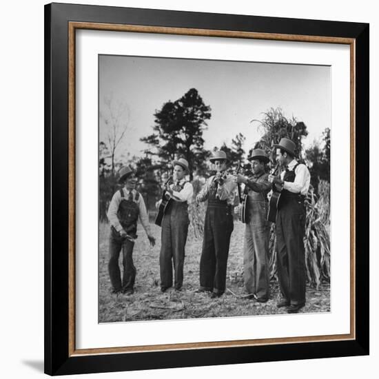 Five Male Musicians Dressed in Hats and Bib Overalls Standing in a Field-Eric Schaal-Framed Photographic Print