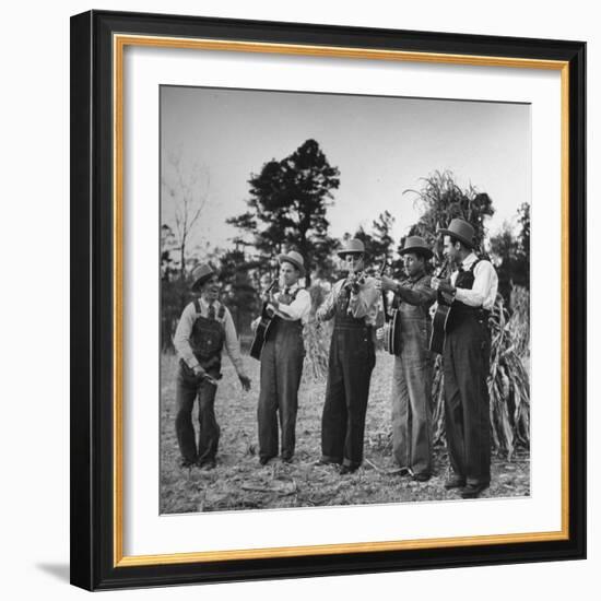 Five Male Musicians Dressed in Hats and Bib Overalls Standing in a Field-Eric Schaal-Framed Photographic Print