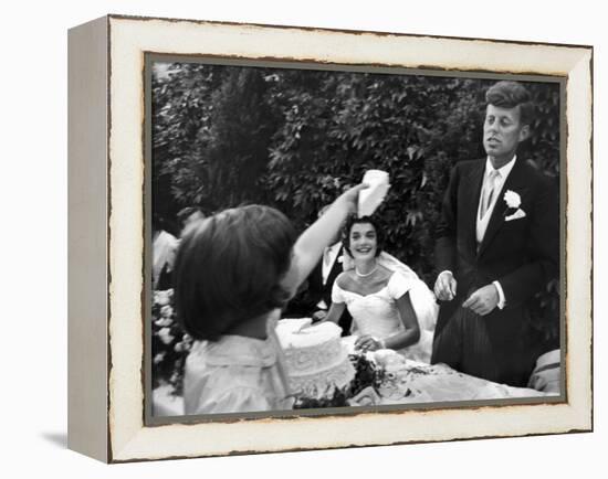 Flower Girl Janet Auchincloss Holding Up a Wedge of Wedding Cake for Bridegroom Sen. John Kennedy-Lisa Larsen-Framed Premier Image Canvas