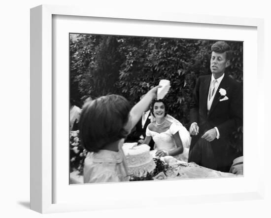 Flower Girl Janet Auchincloss Holding Up a Wedge of Wedding Cake for Bridegroom Sen. John Kennedy-Lisa Larsen-Framed Photographic Print