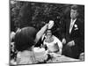 Flower Girl Janet Auchincloss Holding Up a Wedge of Wedding Cake for Bridegroom Sen. John Kennedy-Lisa Larsen-Mounted Photographic Print