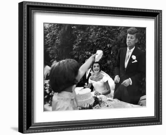 Flower Girl Janet Auchincloss Holding Up a Wedge of Wedding Cake for Bridegroom Sen. John Kennedy-Lisa Larsen-Framed Photographic Print