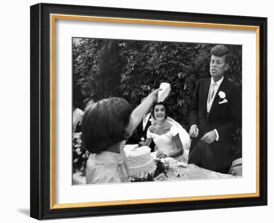 Flower Girl Janet Auchincloss Holding Up a Wedge of Wedding Cake for Bridegroom Sen. John Kennedy-Lisa Larsen-Framed Photographic Print