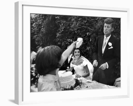 Flower Girl Janet Auchincloss Holding Up a Wedge of Wedding Cake for Bridegroom Sen. John Kennedy-Lisa Larsen-Framed Photographic Print