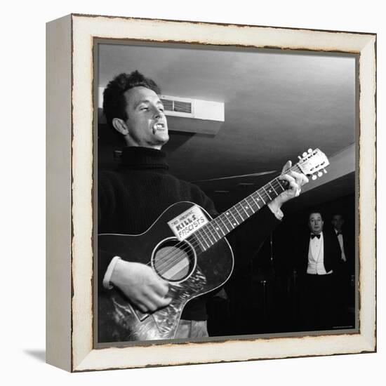 Folk Singer Woody Guthie Performing with Guitar Emblazoned with "This Machine Kills Fascists"-Eric Schaal-Framed Premier Image Canvas