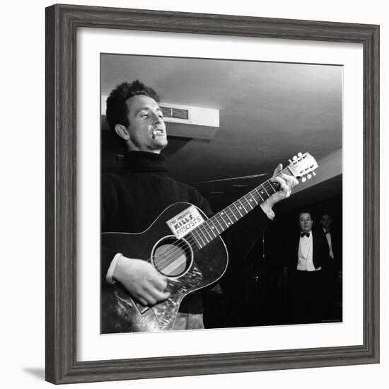 Folk Singer Woody Guthie Performing with Guitar Emblazoned with "This Machine Kills Fascists"-Eric Schaal-Framed Premium Photographic Print