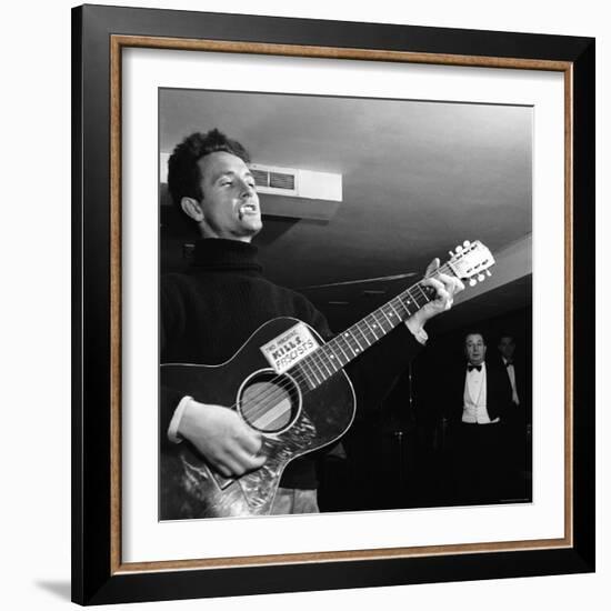 Folk Singer Woody Guthie Performing with Guitar Emblazoned with "This Machine Kills Fascists"-Eric Schaal-Framed Premium Photographic Print