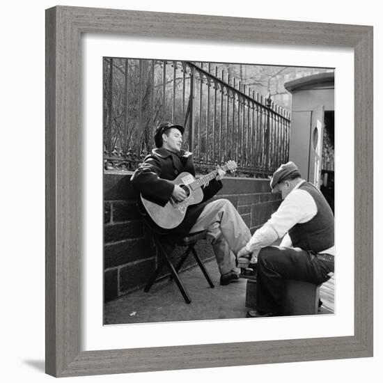 Folk Singer Woody Guthrie Palying His Guitar While Getting a Shoeshine-null-Framed Premium Photographic Print