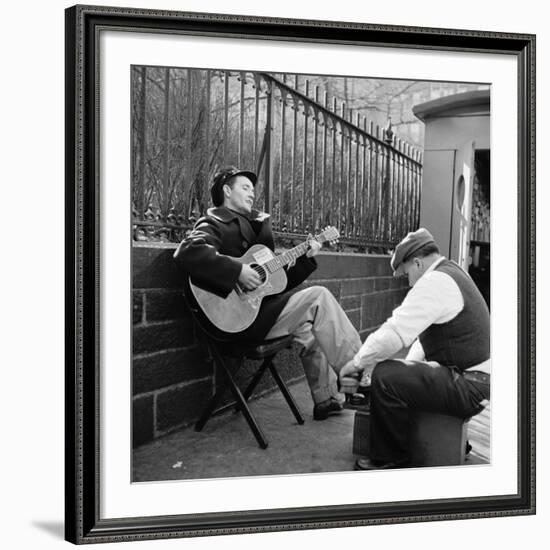 Folk Singer Woody Guthrie Palying His Guitar While Getting a Shoeshine-null-Framed Premium Photographic Print