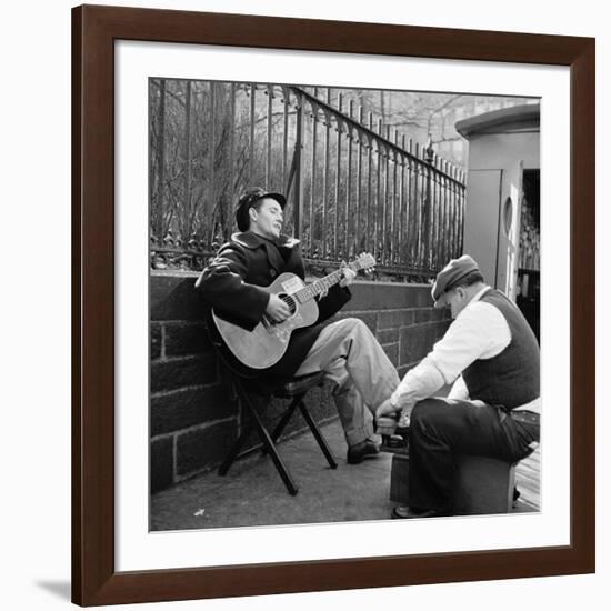 Folk Singer Woody Guthrie Palying His Guitar While Getting a Shoeshine-null-Framed Premium Photographic Print