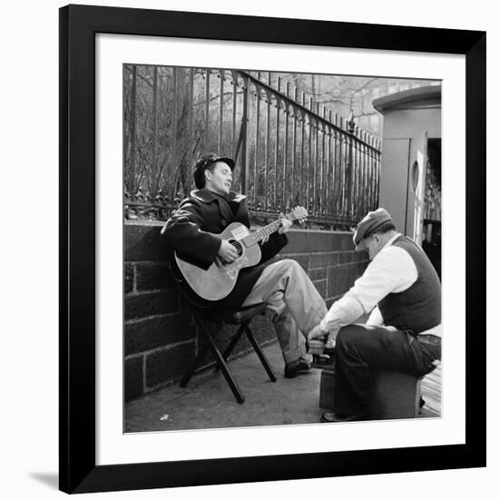 Folk Singer Woody Guthrie Palying His Guitar While Getting a Shoeshine-null-Framed Premium Photographic Print