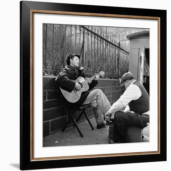 Folk Singer Woody Guthrie Palying His Guitar While Getting a Shoeshine-null-Framed Premium Photographic Print