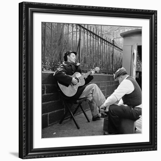 Folk Singer Woody Guthrie Palying His Guitar While Getting a Shoeshine-null-Framed Premium Photographic Print