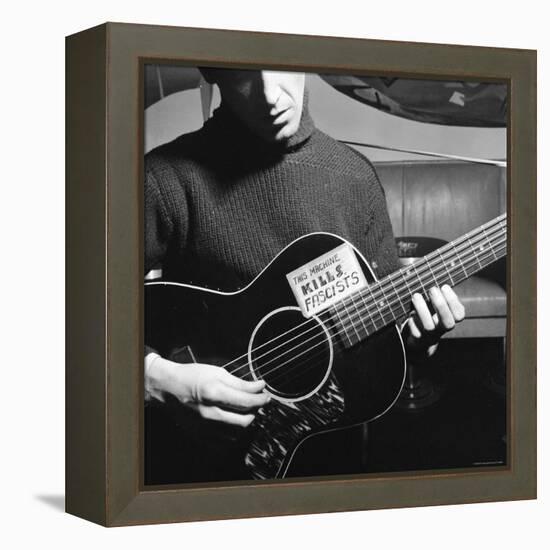 Folk Singer Woody Guthrie Playing Guitar with Sign on It Reading This Machine Kills Fascists-Eric Schaal-Framed Premier Image Canvas