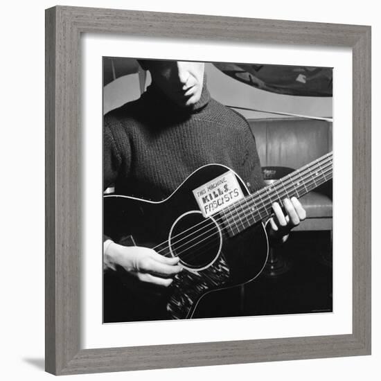 Folk Singer Woody Guthrie Playing Guitar with Sign on It Reading This Machine Kills Fascists-Eric Schaal-Framed Premium Photographic Print