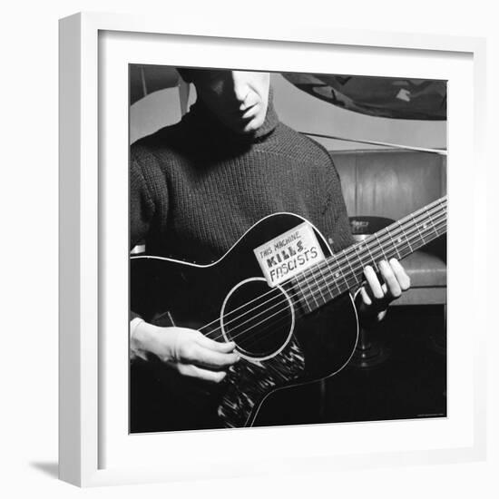 Folk Singer Woody Guthrie Playing Guitar with Sign on It Reading This Machine Kills Fascists-Eric Schaal-Framed Premium Photographic Print