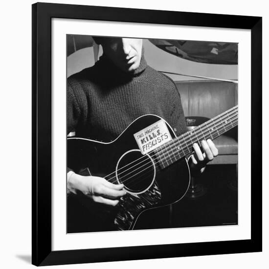 Folk Singer Woody Guthrie Playing Guitar with Sign on It Reading This Machine Kills Fascists-Eric Schaal-Framed Premium Photographic Print