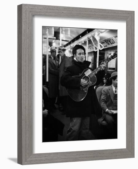 Folk Singer Woody Guthrie Singing Aboard a Subway Train-null-Framed Premium Photographic Print