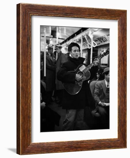 Folk Singer Woody Guthrie Singing Aboard a Subway Train-null-Framed Premium Photographic Print